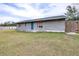 Ranch style home with gray siding, blue door, and grassy yard at 14430 10Th St, Dade City, FL 33523