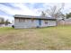 House exterior showcasing gray siding and a grassy yard at 14430 10Th St, Dade City, FL 33523