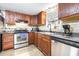 Stainless steel appliances and dark wood cabinets in kitchen at 14430 10Th. St, Dade City, FL 33523