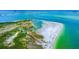 Aerial view of waterfront property with lush greenery and white sand beach at 1485 Halsey Dr # 101, Dunedin, FL 34698