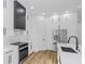 Modern kitchen with white cabinets, stainless steel appliances and hardwood floors at 1696 Wilmar Ave, Tarpon Springs, FL 34689