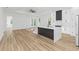 Modern kitchen with white cabinets, large island, and hardwood floors at 1696 Wilmar Ave, Tarpon Springs, FL 34689