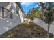 Narrow side yard with new landscaping and a white fence at 1696 Wilmar Ave, Tarpon Springs, FL 34689