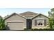 Single-story home with gray siding, stone accents, and a two-car garage at 1714 Tahitian Sunrise Dr, Plant City, FL 33565