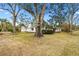 Side view of house with large trees and lawn at 1758 Winfield Cir, Clearwater, FL 33756