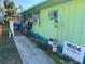 Front view of a colorful beach cottage with walkway and signage at 18006 4Th E St, Redington Shores, FL 33708
