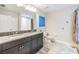 Double vanity bathroom with granite countertops and a large mirror at 18811 Deer Tracks Loop, Lutz, FL 33558