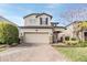 Two-story house with beige exterior, brick driveway, and landscaping at 18811 Deer Tracks Loop, Lutz, FL 33558