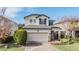 Two-story home with beige exterior, two-car garage, and landscaping at 18811 Deer Tracks Loop, Lutz, FL 33558
