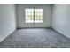 Well-lit bedroom featuring a large window and carpet at 19018 Geraci Rd, Lutz, FL 33548