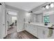 Modern bathroom with double vanity,white cabinets, and grey wood-look floors at 2704 W Gray St # B, Tampa, FL 33609