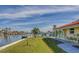 Landscaped backyard with water views and patio at 2801 Hibiscus W Dr, Belleair Beach, FL 33786