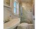 Updated bathroom with marble shower and flooring, white pedestal sink, and window at 2801 Hibiscus W Dr, Belleair Beach, FL 33786