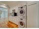 Laundry room with white cabinets, stackable washer and dryer, and tile floor at 2801 Hibiscus W Dr, Belleair Beach, FL 33786