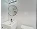 Clean bathroom with white vanity, round mirror, and toilet at 401 Dorchester Pl # 52, Sun City Center, FL 33573