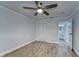 Bright bedroom with ceiling fan, wood-look floors, and an adjacent bathroom at 401 Dorchester Pl # 52, Sun City Center, FL 33573