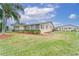 Tan single story home with green lawn and palm trees at 401 Dorchester Pl # 52, Sun City Center, FL 33573