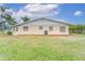Rear view of house showing yard and AC unit at 401 Dorchester Pl # 52, Sun City Center, FL 33573
