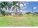 Tan single story home with palm trees and well-manicured lawn at 401 Dorchester Pl # 52, Sun City Center, FL 33573