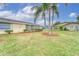 Tan single story home with lush green landscaping at 401 Dorchester Pl # 52, Sun City Center, FL 33573