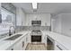 Modern kitchen with white cabinets, quartz countertops, and stainless steel appliances at 401 Dorchester Pl # 52, Sun City Center, FL 33573