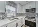 Modern kitchen features white cabinets, black and white tile backsplash at 401 Dorchester Pl # 52, Sun City Center, FL 33573