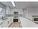 Modern kitchen features white cabinets, black and white tile backsplash at 401 Dorchester Pl # 52, Sun City Center, FL 33573