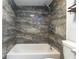 Clean bathroom with a shower/tub combo and marble tile at 4611 W North B St # 129, Tampa, FL 33609