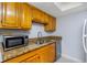 Kitchen with wood cabinets, granite counters, and stainless steel appliances at 4611 W North B St # 129, Tampa, FL 33609