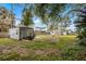 Spacious backyard with storage shed and large trees at 605 Shore E Dr, Oldsmar, FL 34677