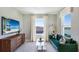 Cozy sitting room with emerald green sofa, large windows, and lake views at 6724 Broad River Ave, Land O Lakes, FL 34638