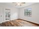 Bright bedroom with wood-look floors, French doors to the backyard, and a ceiling fan at 705 Hidden Lake Dr, Brandon, FL 33511