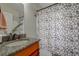 Clean bathroom with granite countertop, updated vanity, and shower with patterned curtain at 720 Sunset Dr, Tarpon Springs, FL 34689