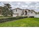 Two-story house with a landscaped lawn, stone accents, and a two-car garage at 720 Sunset Dr, Tarpon Springs, FL 34689
