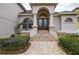 Elegant entryway with double doors, stone accents, and a brick walkway at 720 Sunset Dr, Tarpon Springs, FL 34689