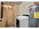 Laundry room with washer, dryer, and water heater; access to stairs at 720 Sunset Dr, Tarpon Springs, FL 34689