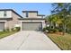 Two-story house with gray siding, two-car garage, and landscaping at 7204 Samuel Ivy Dr, Tampa, FL 33619