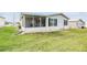 Screened porch and grassy backyard with a view of neighbor at 7800 Kay Marie Ave, Zephyrhills, FL 33541