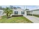 Single-wide manufactured home with carport and landscaped yard at 7800 Kay Marie Ave, Zephyrhills, FL 33541