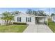 Single-wide manufactured home with carport and landscaped yard at 7800 Kay Marie Ave, Zephyrhills, FL 33541