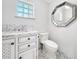 Modern bathroom with marble vanity, white toilet, and octagonal mirror at 9050 San Martin Ne Blvd, St Petersburg, FL 33702