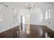 Spacious bedroom with dark hardwood floors, chandelier, and en-suite bathroom access at 9050 San Martin Ne Blvd, St Petersburg, FL 33702