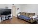Living room with brown couch, large TV, and wood-look flooring at 1000 79Th N Ave # 102, St Petersburg, FL 33702