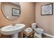 Powder room with pedestal sink, toilet, and decorative wall art at 10266 Kalamazoo Pl, Parrish, FL 34219