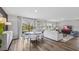 Open concept dining area with round table and chairs, hardwood floors and access to the back yard at 10266 Kalamazoo Pl, Parrish, FL 34219