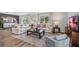 Bright living room featuring comfortable sofas, a large TV, and hardwood floors at 10266 Kalamazoo Pl, Parrish, FL 34219