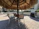 Outdoor grilling area with tables and chairs under a thatched roof at 106 1St E St # 115, St Petersburg, FL 33715