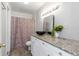 Bathroom with granite countertop, black vessel sink, and floral shower curtain at 1619 E Nome St, Tampa, FL 33604