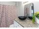 Bathroom with granite countertop, black vessel sink, and floral shower curtain at 1619 E Nome St, Tampa, FL 33604