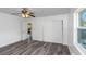 Bedroom with grey vinyl flooring, ceiling fan, and access to another room at 1619 E Nome St, Tampa, FL 33604